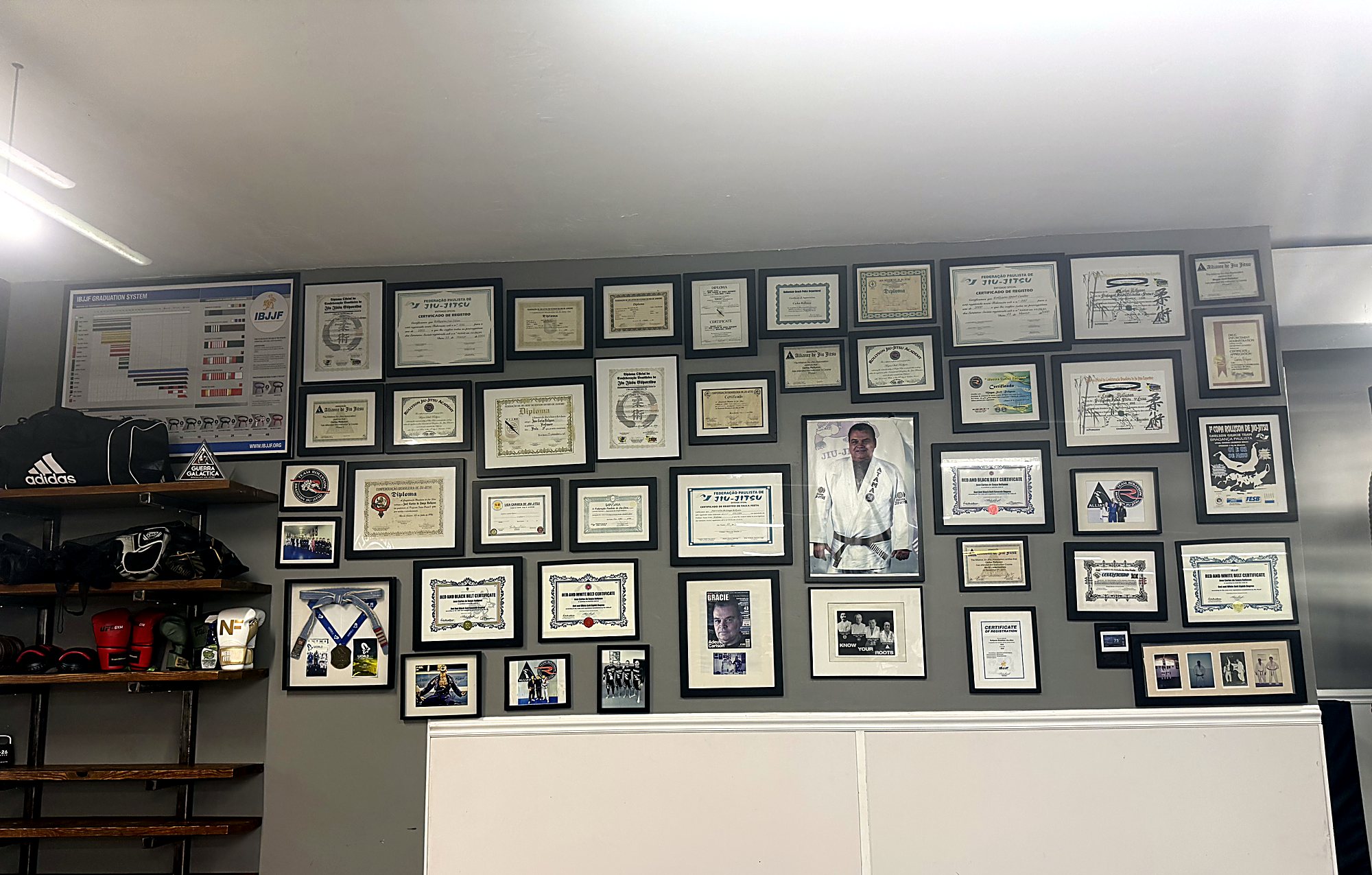 Wall of certificates and lineage photos at Rollyson Brazilian Jiu Jitsu